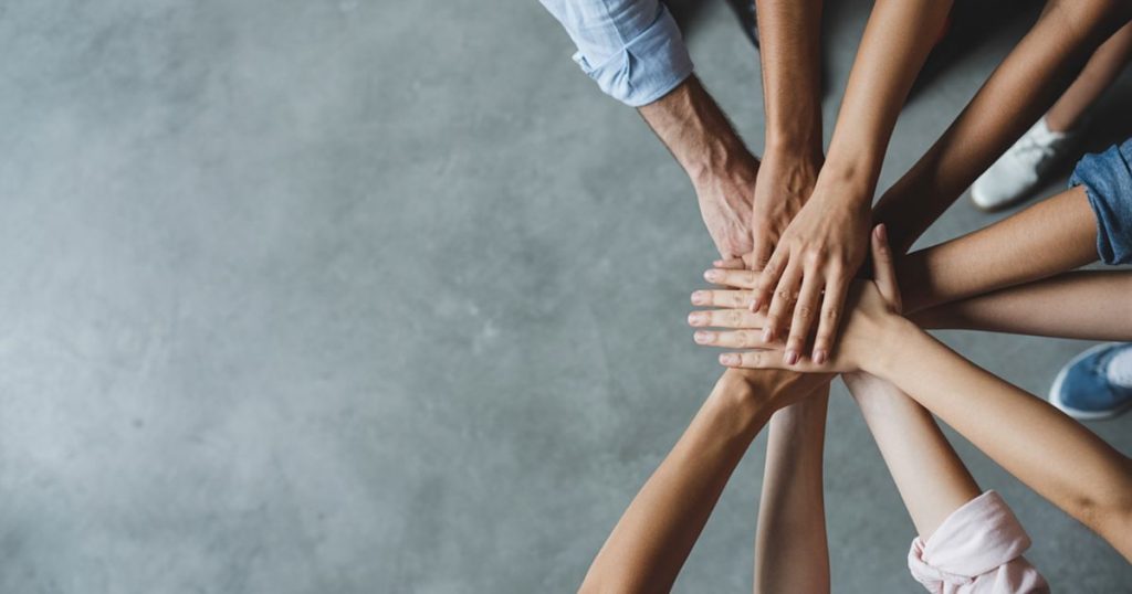 Team with hands stacked together in a circle